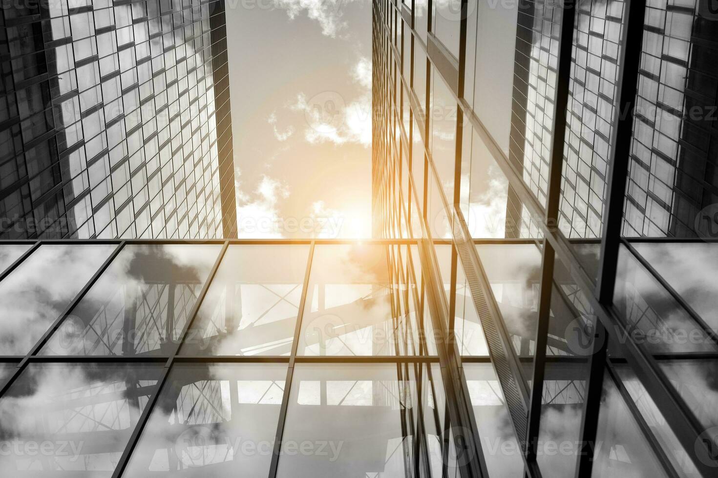 Modern architectural details. Modern glass facade with a geometric pattern. Contemporary corporate business architecture. Red sun on horizon. Black and white toned image. photo