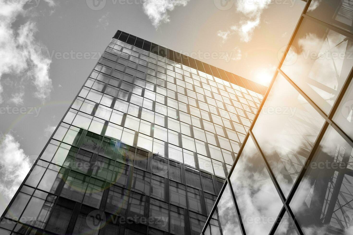 Modern architectural details. Modern glass facade with a geometric pattern. Contemporary corporate business architecture. Red sun on horizon. Black and white toned image. photo