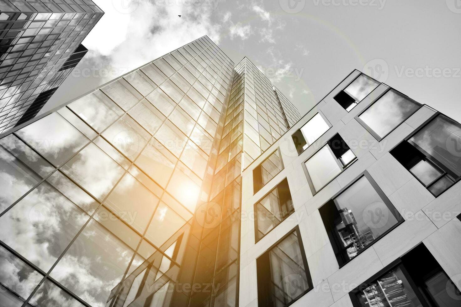 Modern architectural details. Modern glass facade with a geometric pattern. Contemporary corporate business architecture. Red sun on horizon. Black and white toned image. photo
