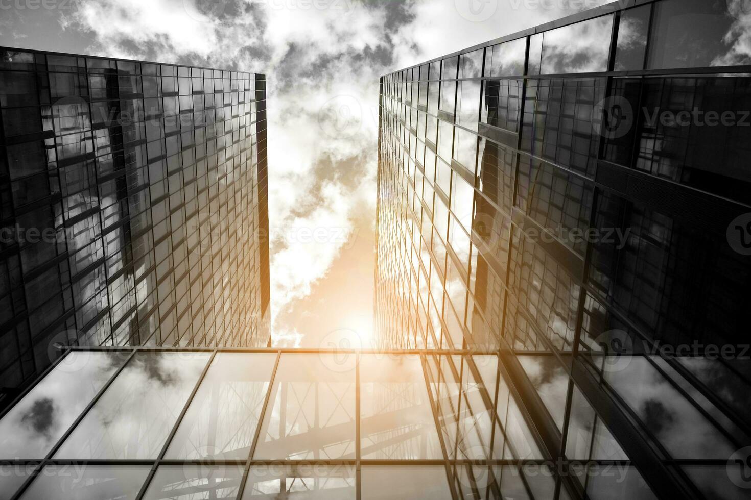Modern architectural details. Modern glass facade with a geometric pattern. Contemporary corporate business architecture. Red sun on horizon. Black and white toned image. photo