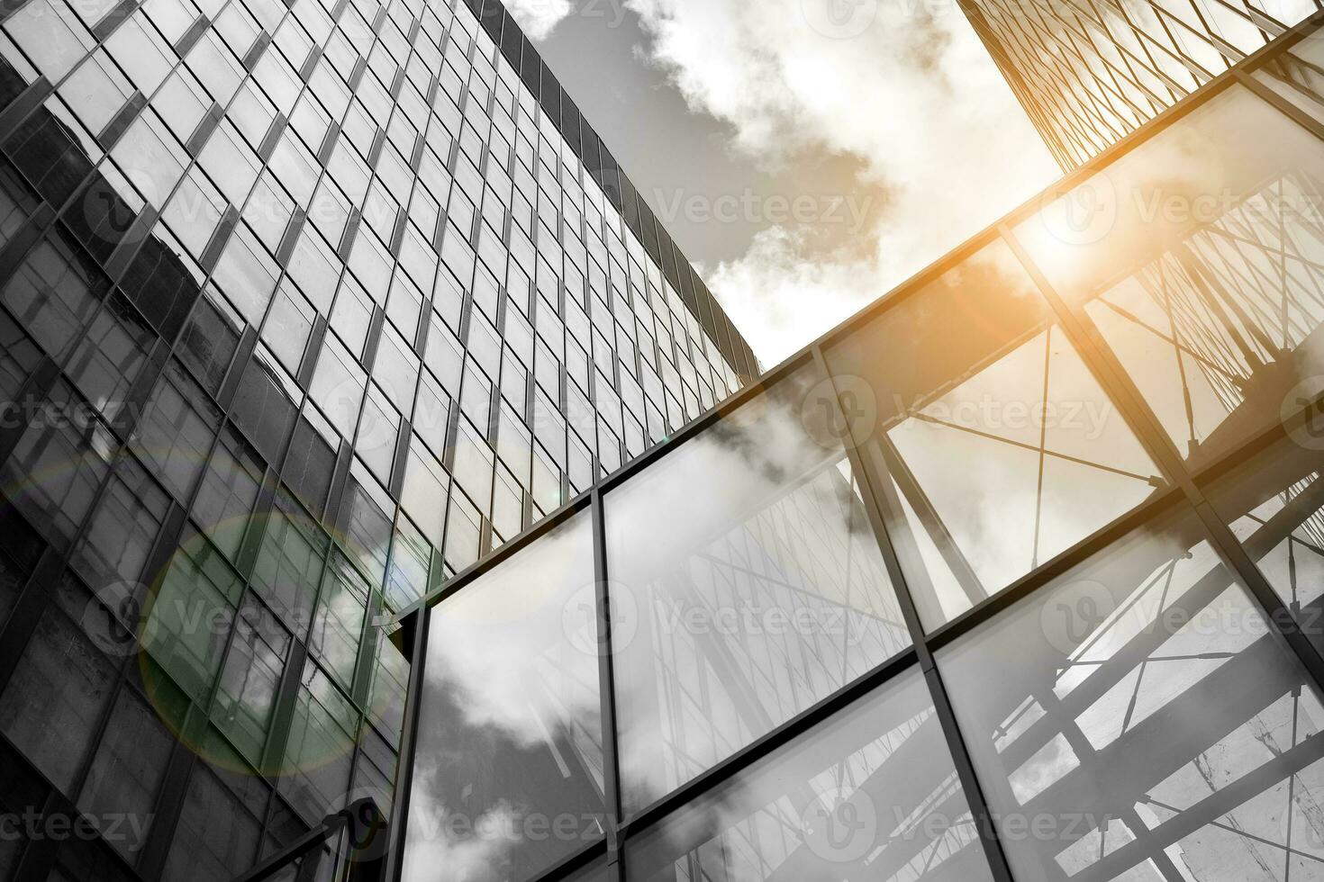Modern architectural details. Modern glass facade with a geometric pattern. Contemporary corporate business architecture. Red sun on horizon. Black and white toned image. photo