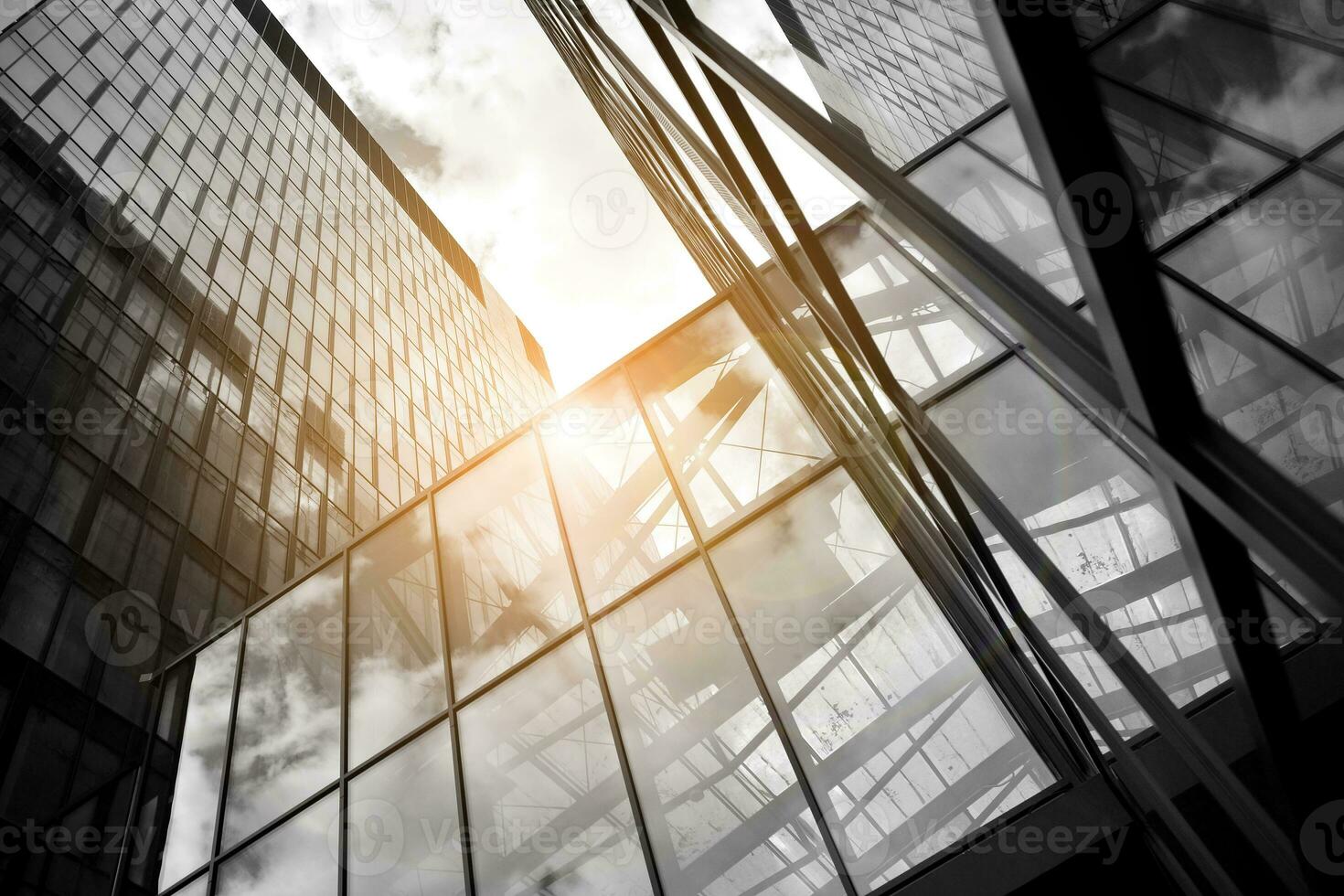 Modern architectural details. Modern glass facade with a geometric pattern. Contemporary corporate business architecture. Red sun on horizon. Black and white toned image. photo