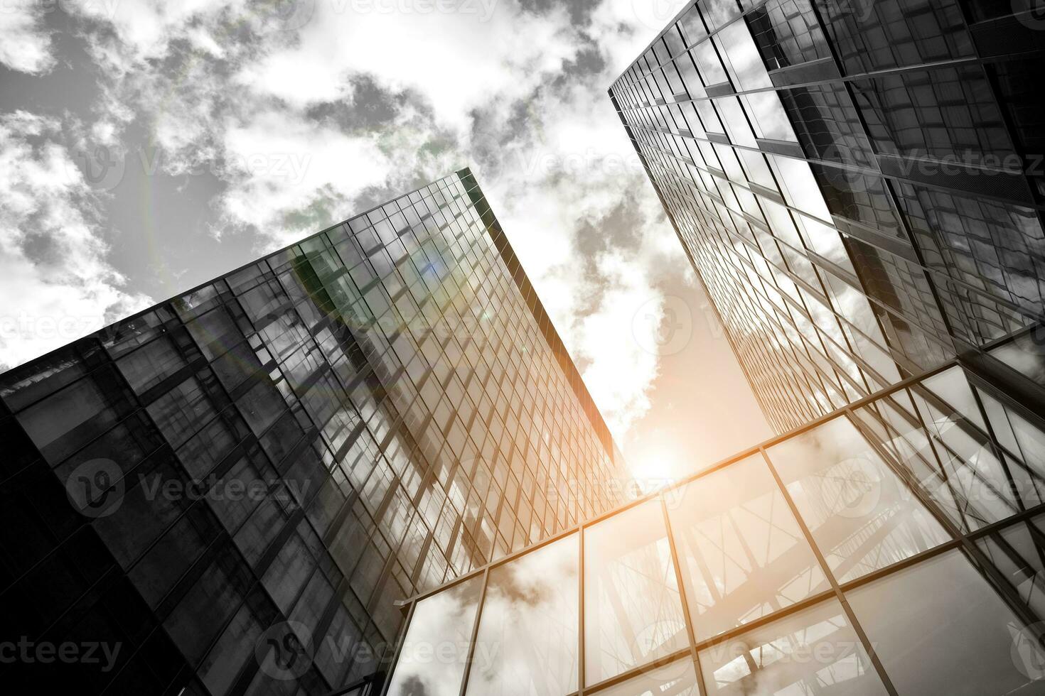 Modern architectural details. Modern glass facade with a geometric pattern. Contemporary corporate business architecture. Red sun on horizon. Black and white toned image. photo