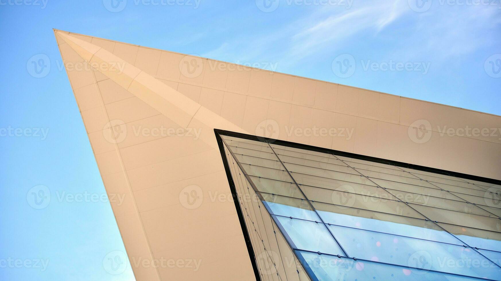 Glass building with transparent facade of the building and blue sky. Structural glass wall reflecting blue sky. Abstract modern architecture fragment. Contemporary architectural background. photo