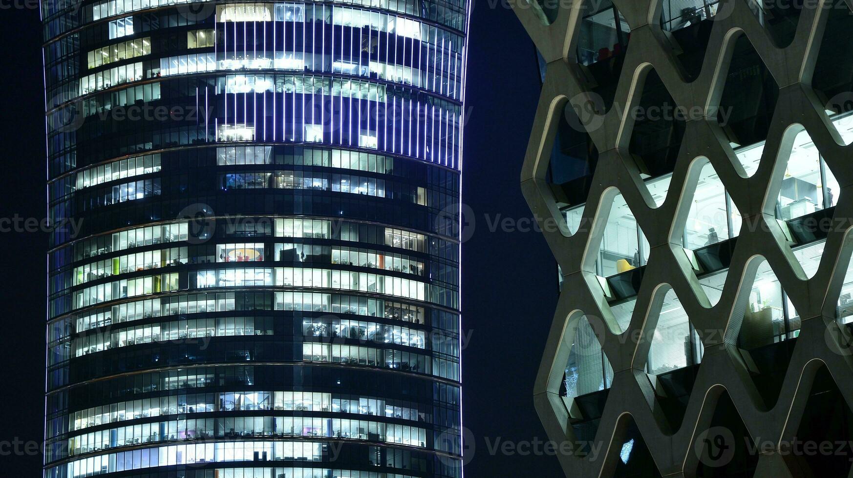 Pattern of office buildings windows illuminated at night. Glass architecture ,corporate building at night - business concept. photo