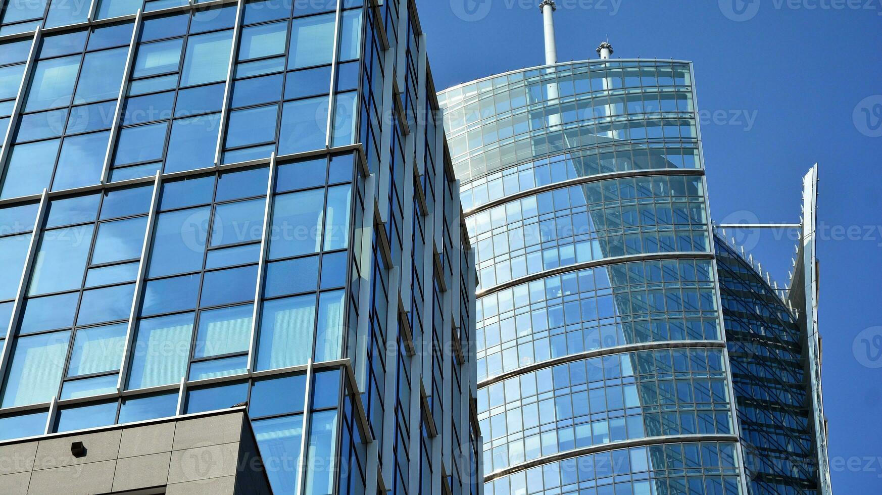 Glass building with transparent facade of the building and blue sky. Structural glass wall reflecting blue sky. Abstract modern architecture fragment. Contemporary architectural background. photo