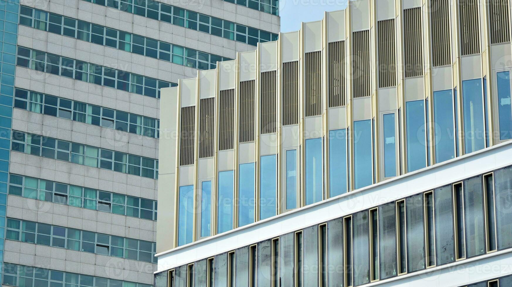 Glass building with transparent facade of the building and blue sky. Structural glass wall reflecting blue sky. Abstract modern architecture fragment. Contemporary architectural background. photo