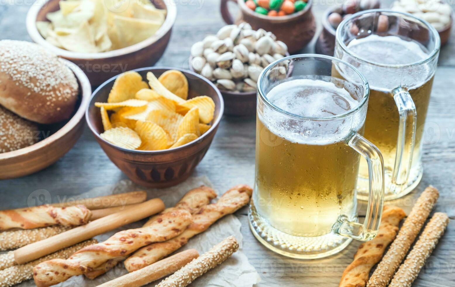 dos lentes de cerveza con aperitivos foto