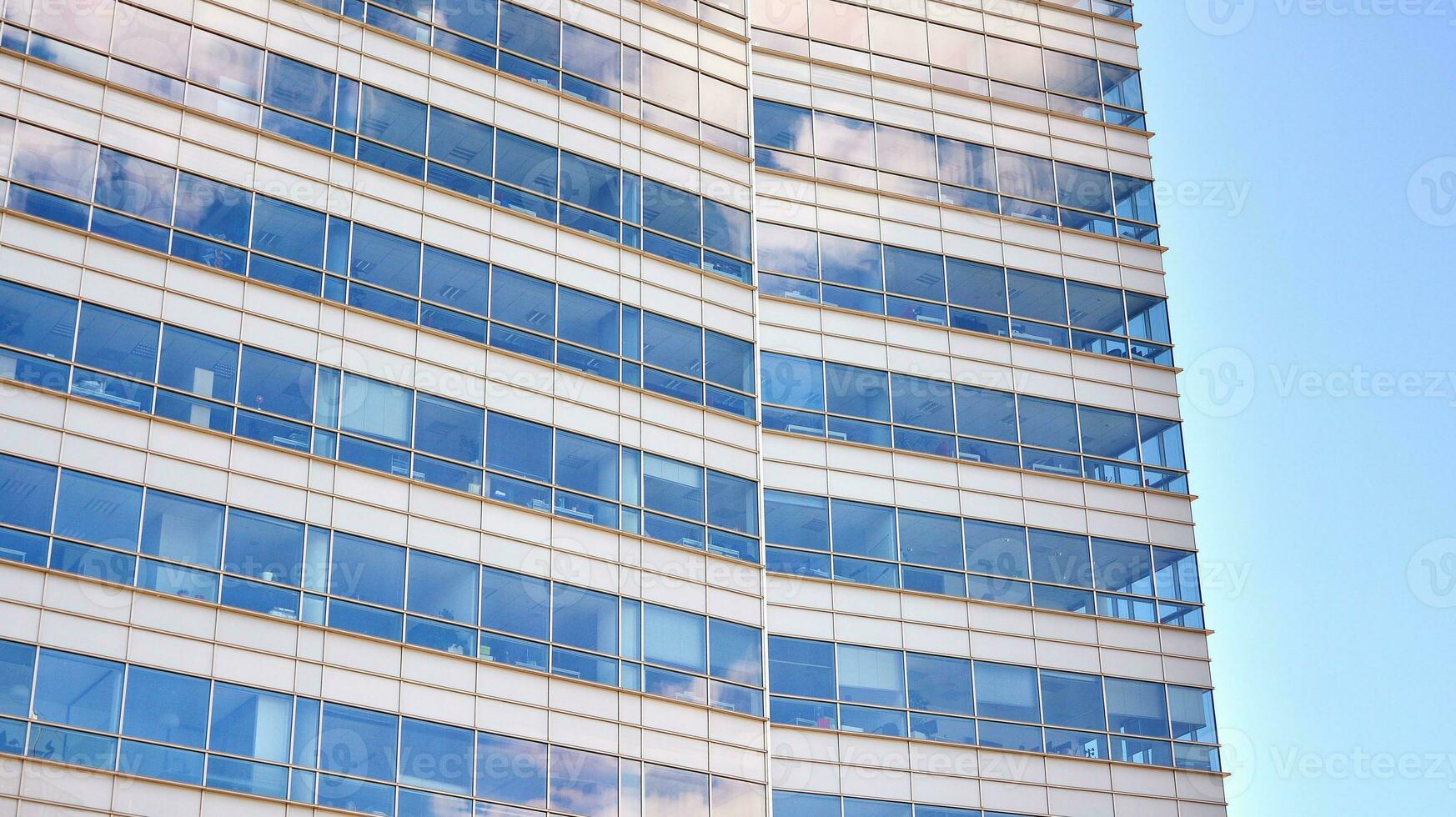 Glass building with transparent facade of the building and blue sky. Structural glass wall reflecting blue sky. Abstract modern architecture fragment. Contemporary architectural background. photo