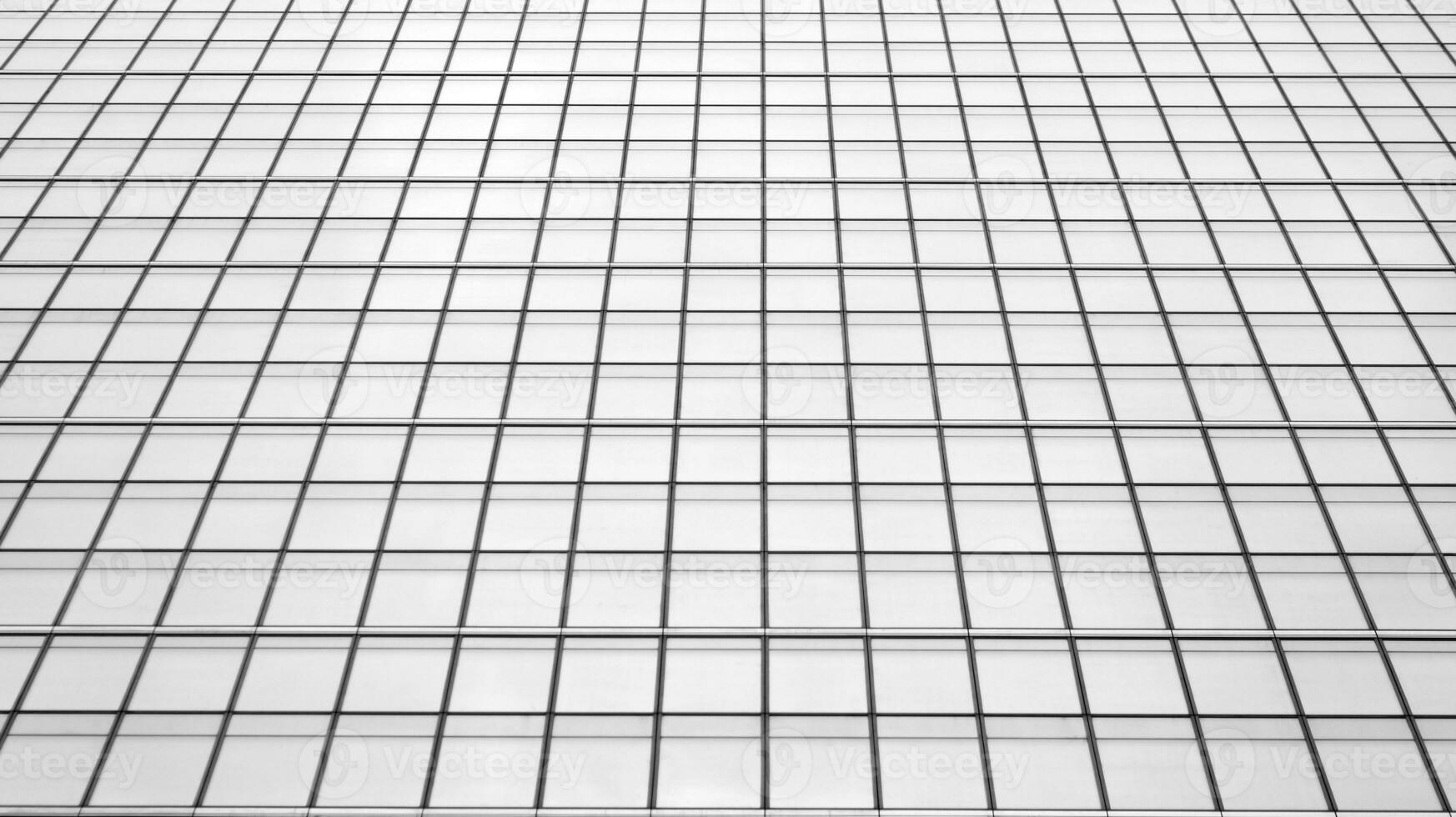 Glass modern building with blue sky background. View and architecture details. Urban abstract - windows of glass office building in  sunlight day. Black and white. photo
