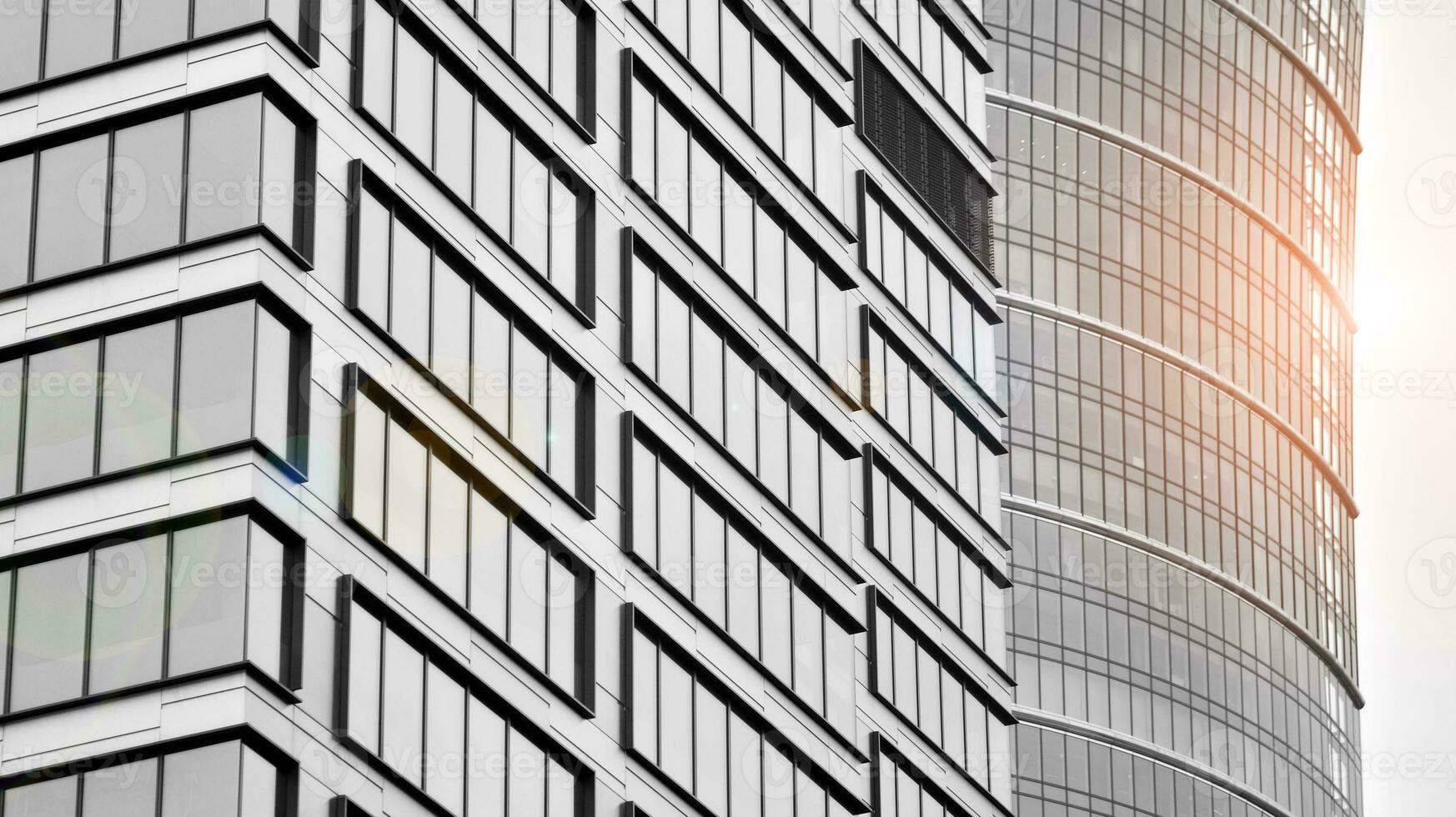 Glass modern building with blue sky background. View and architecture details. Urban abstract - windows of glass office building in  sunlight day. Black and white. photo