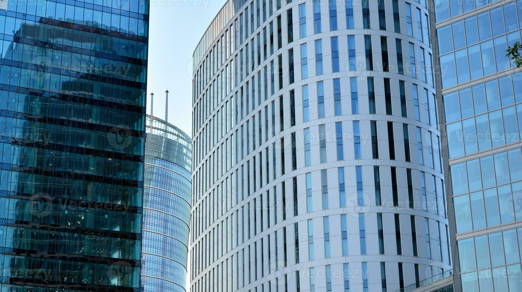 Glass building with transparent facade of the building and blue sky. Structural glass wall reflecting blue sky. Abstract modern architecture fragment. Contemporary architectural background. photo