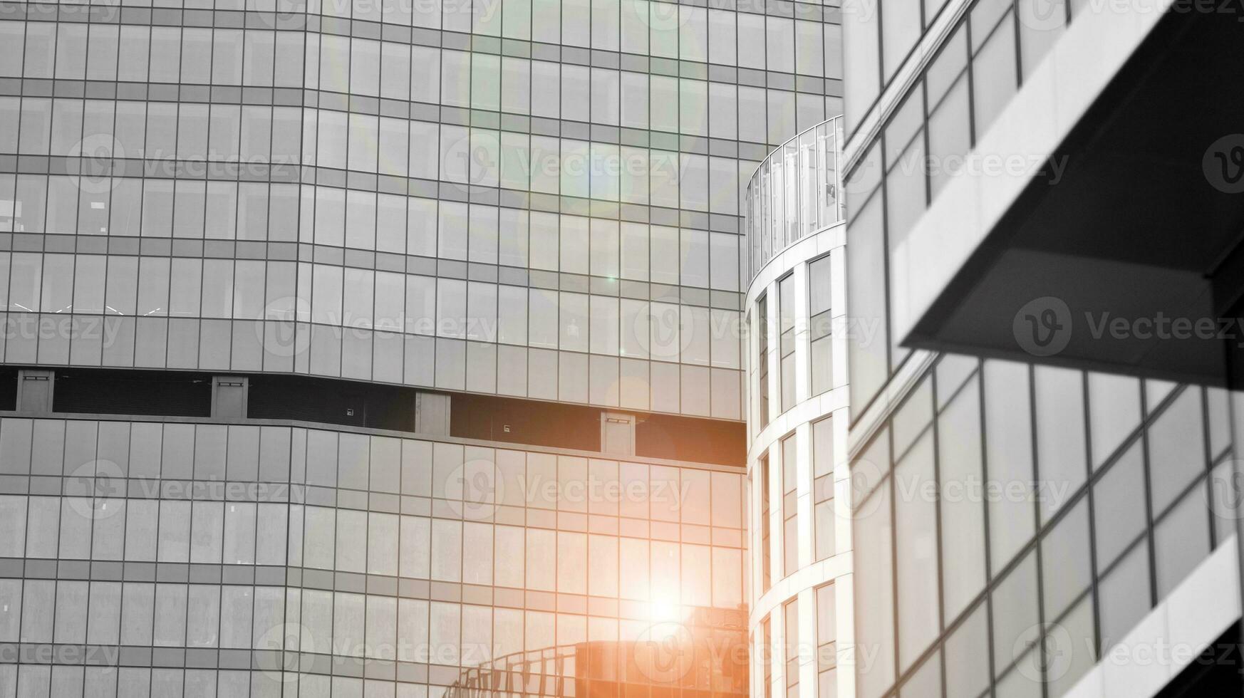 Glass modern building with blue sky background. View and architecture details. Urban abstract - windows of glass office building in  sunlight day. Black and white. photo