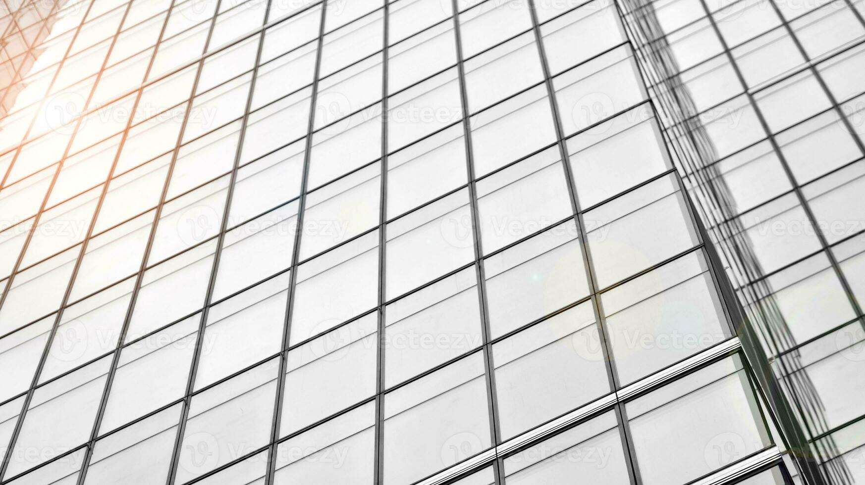 Glass modern building with blue sky background. View and architecture details. Urban abstract - windows of glass office building in  sunlight day. Black and white. photo