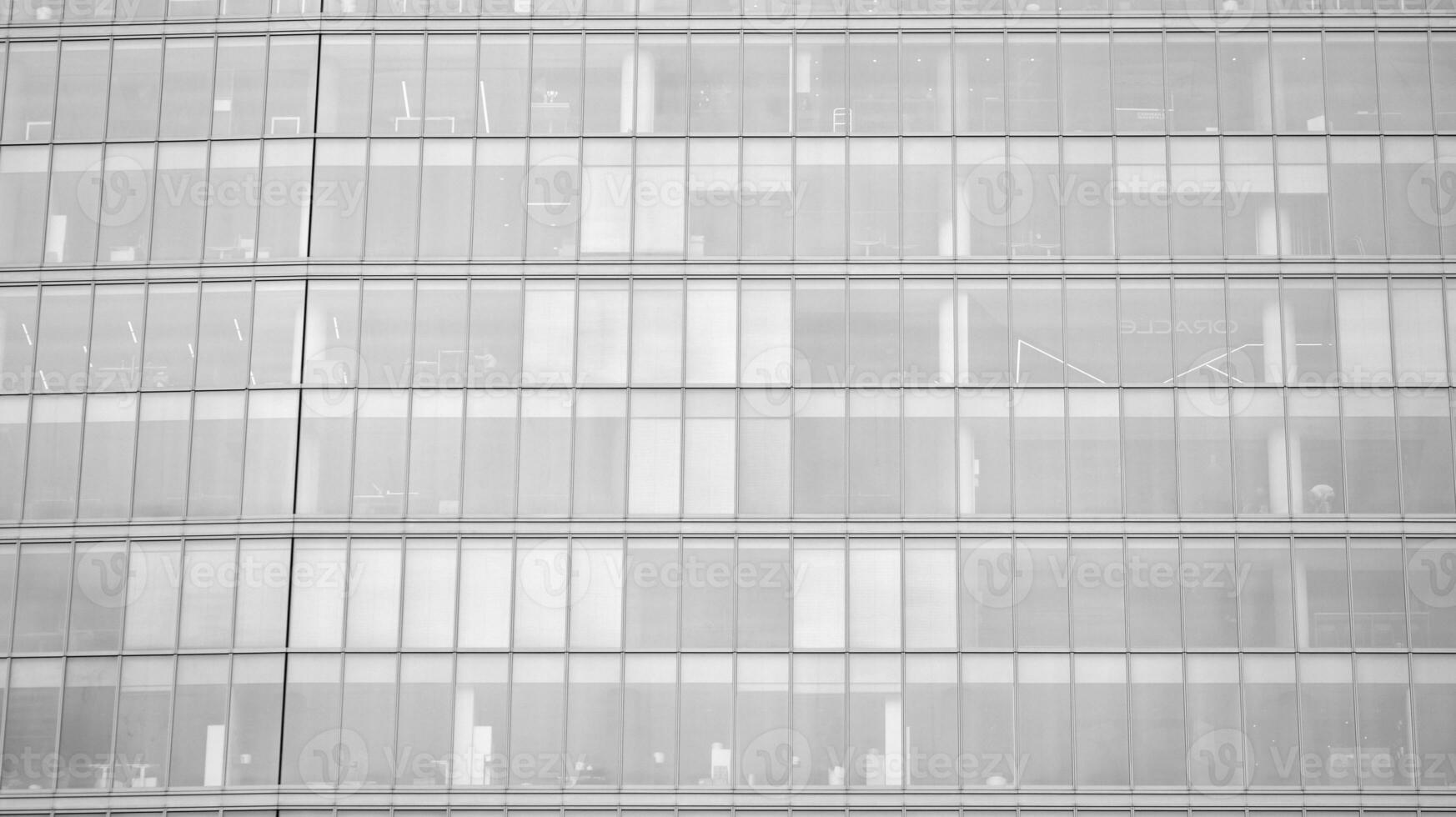 Glass modern building with blue sky background. View and architecture details. Urban abstract - windows of glass office building in  sunlight day. Black and white. photo