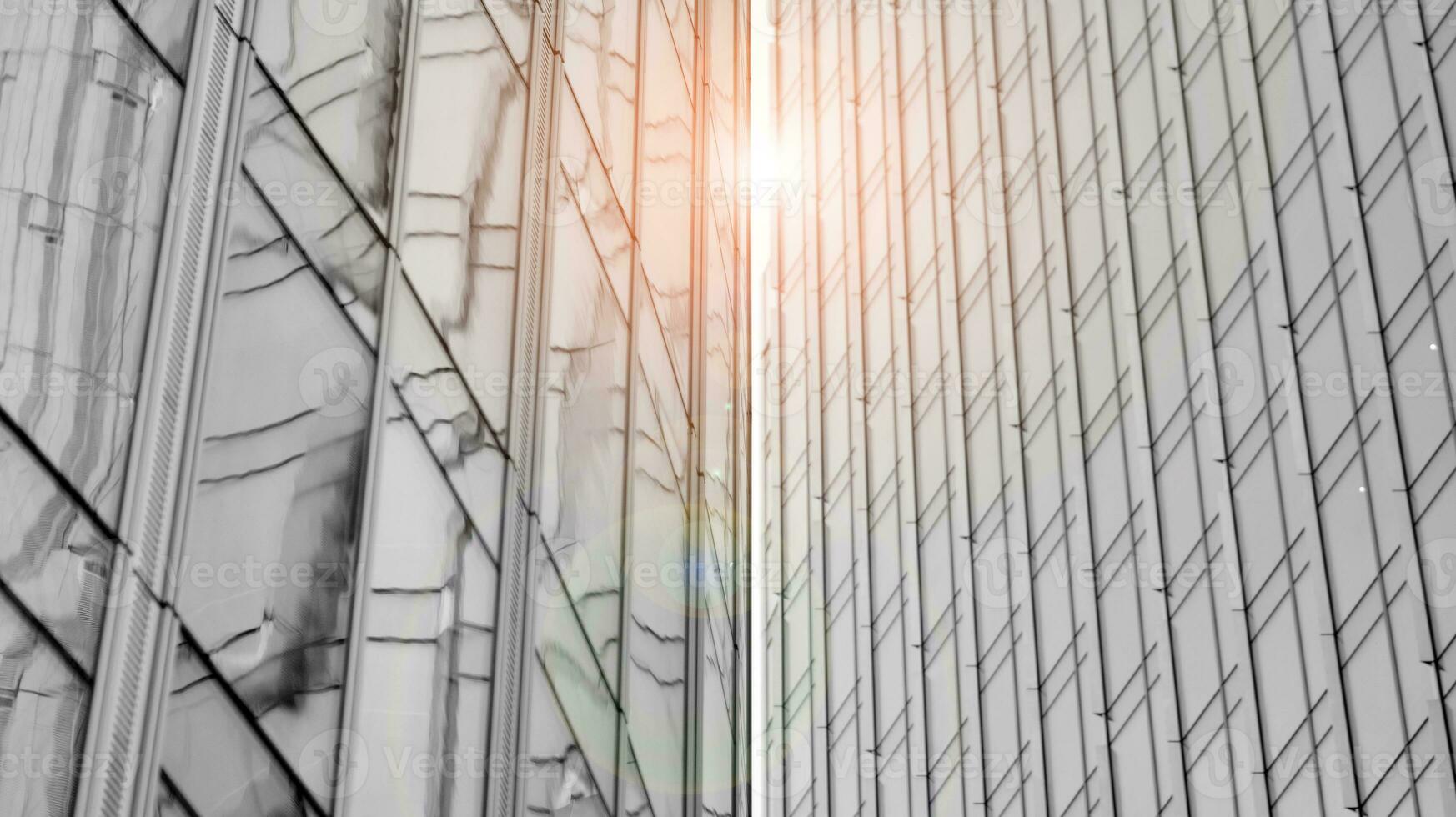 Glass modern building with blue sky background. View and architecture details. Urban abstract - windows of glass office building in  sunlight day. Black and white. photo