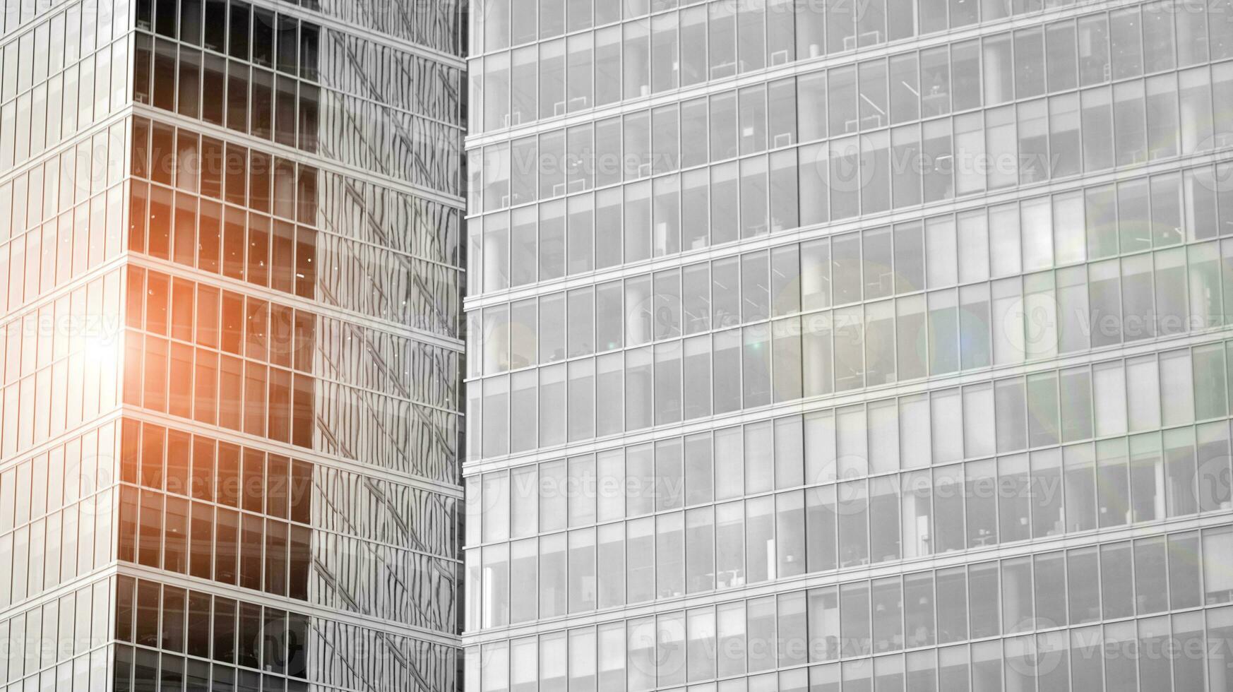 Glass modern building with blue sky background. View and architecture details. Urban abstract - windows of glass office building in  sunlight day. Black and white. photo