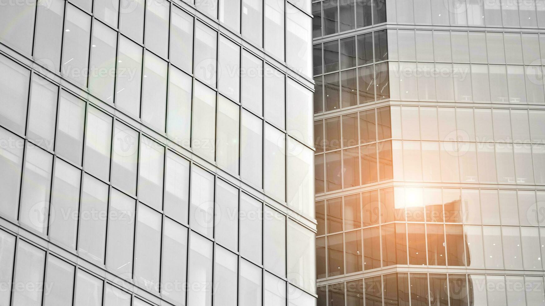 Glass modern building with blue sky background. View and architecture details. Urban abstract - windows of glass office building in  sunlight day. Black and white. photo