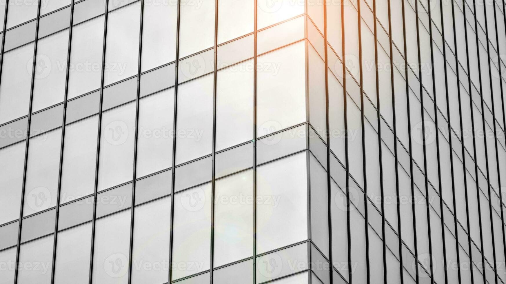 Glass modern building with blue sky background. View and architecture details. Urban abstract - windows of glass office building in  sunlight day. Black and white. photo