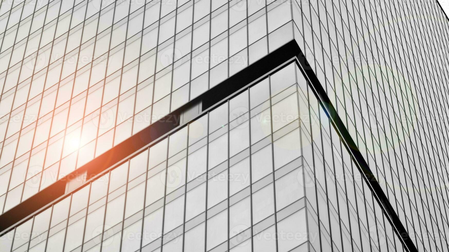 Glass modern building with blue sky background. View and architecture details. Urban abstract - windows of glass office building in  sunlight day. Black and white. photo