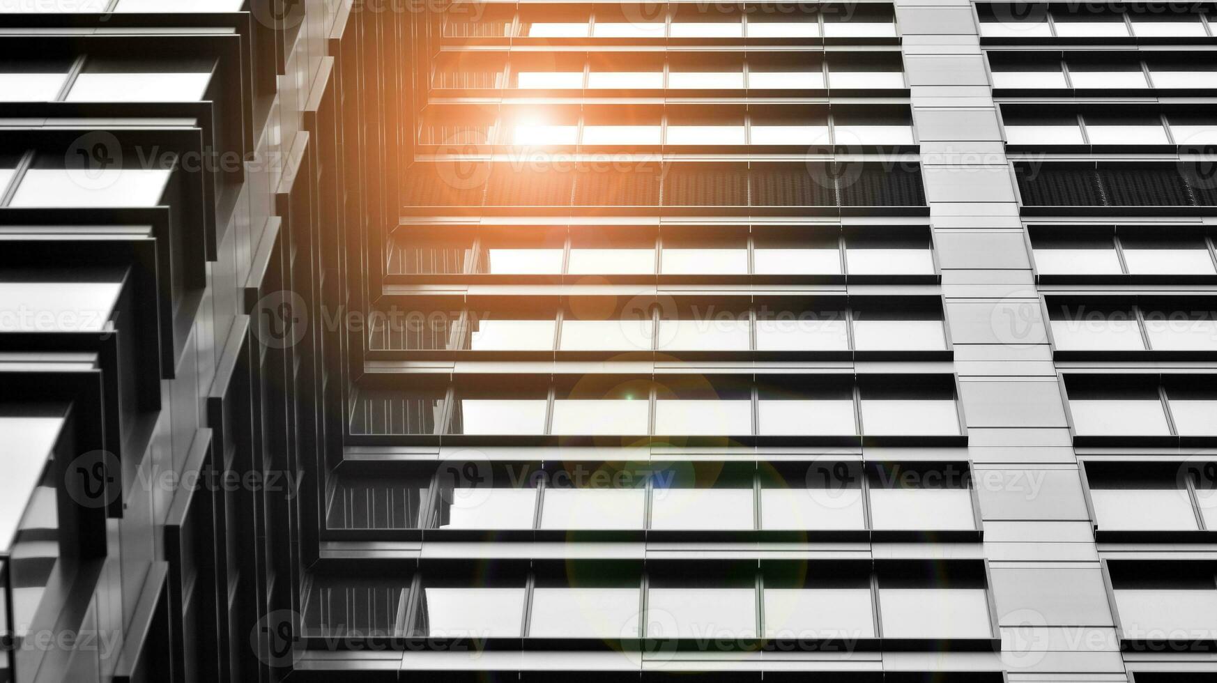 Glass modern building with blue sky background. View and architecture details. Urban abstract - windows of glass office building in  sunlight day. Black and white. photo