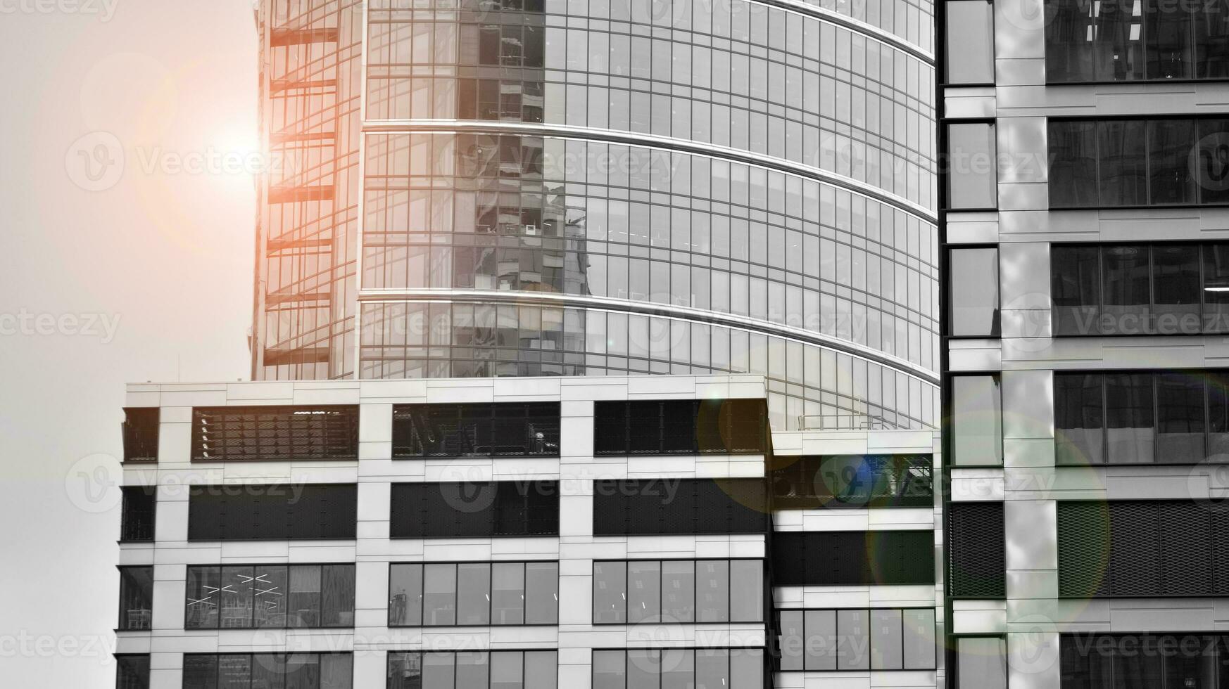 Glass modern building with blue sky background. View and architecture details. Urban abstract - windows of glass office building in  sunlight day. Black and white. photo