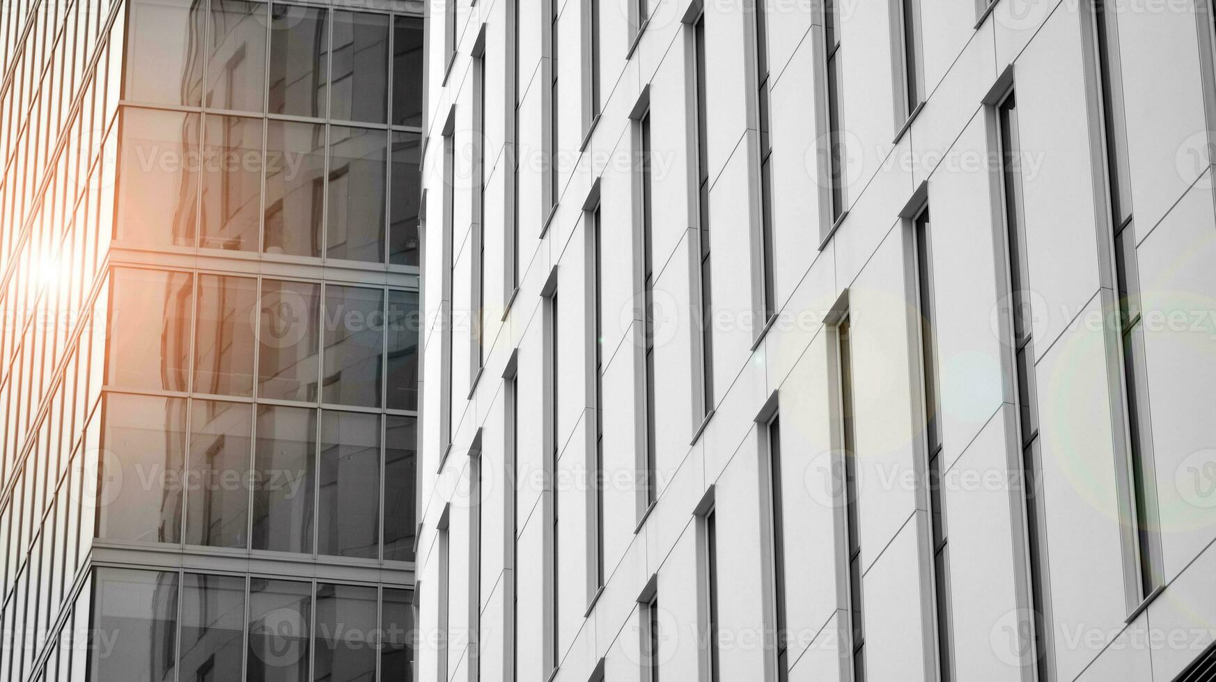 Glass modern building with blue sky background. View and architecture details. Urban abstract - windows of glass office building in  sunlight day. Black and white. photo