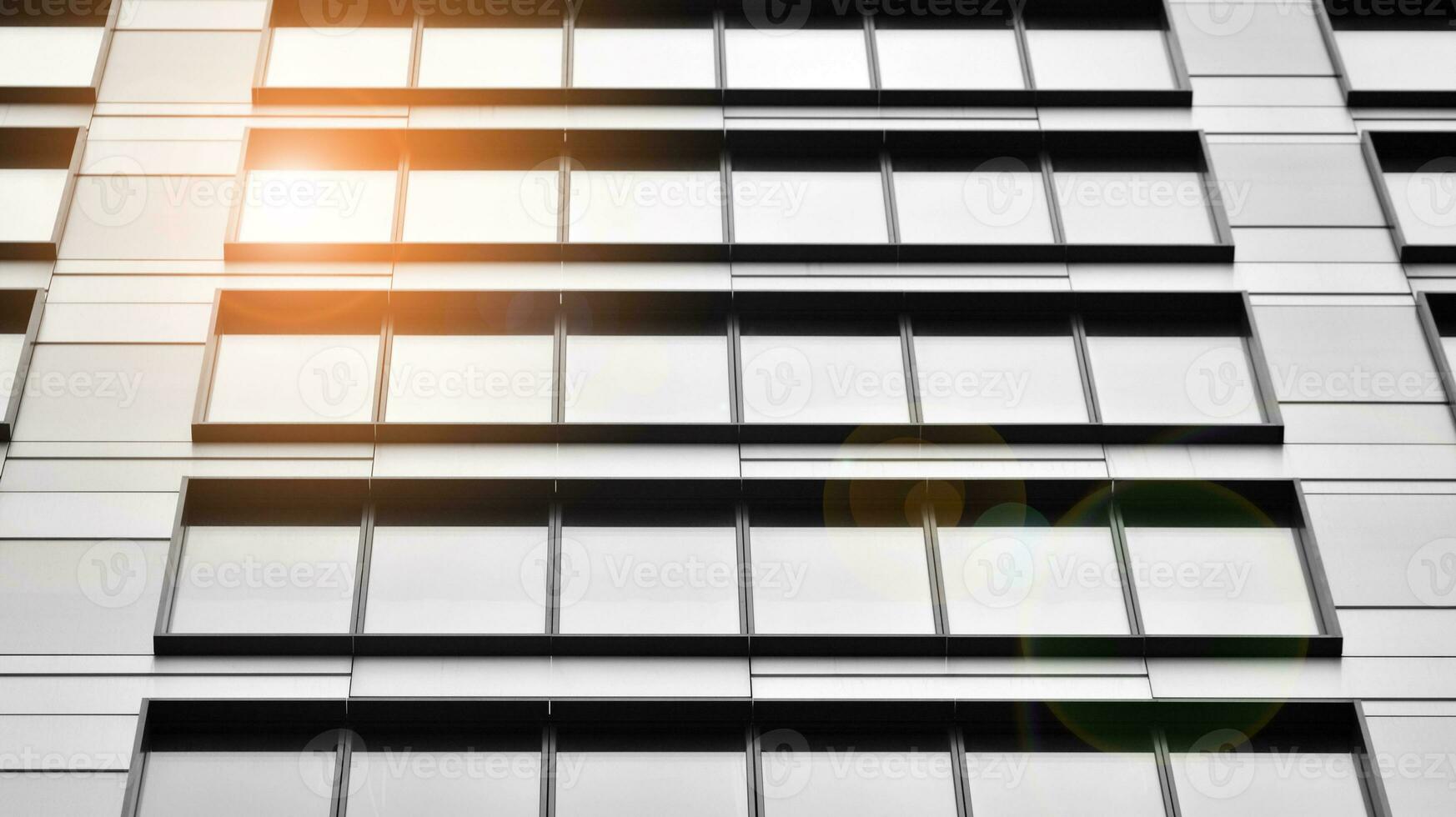 Glass modern building with blue sky background. View and architecture details. Urban abstract - windows of glass office building in  sunlight day. Black and white. photo