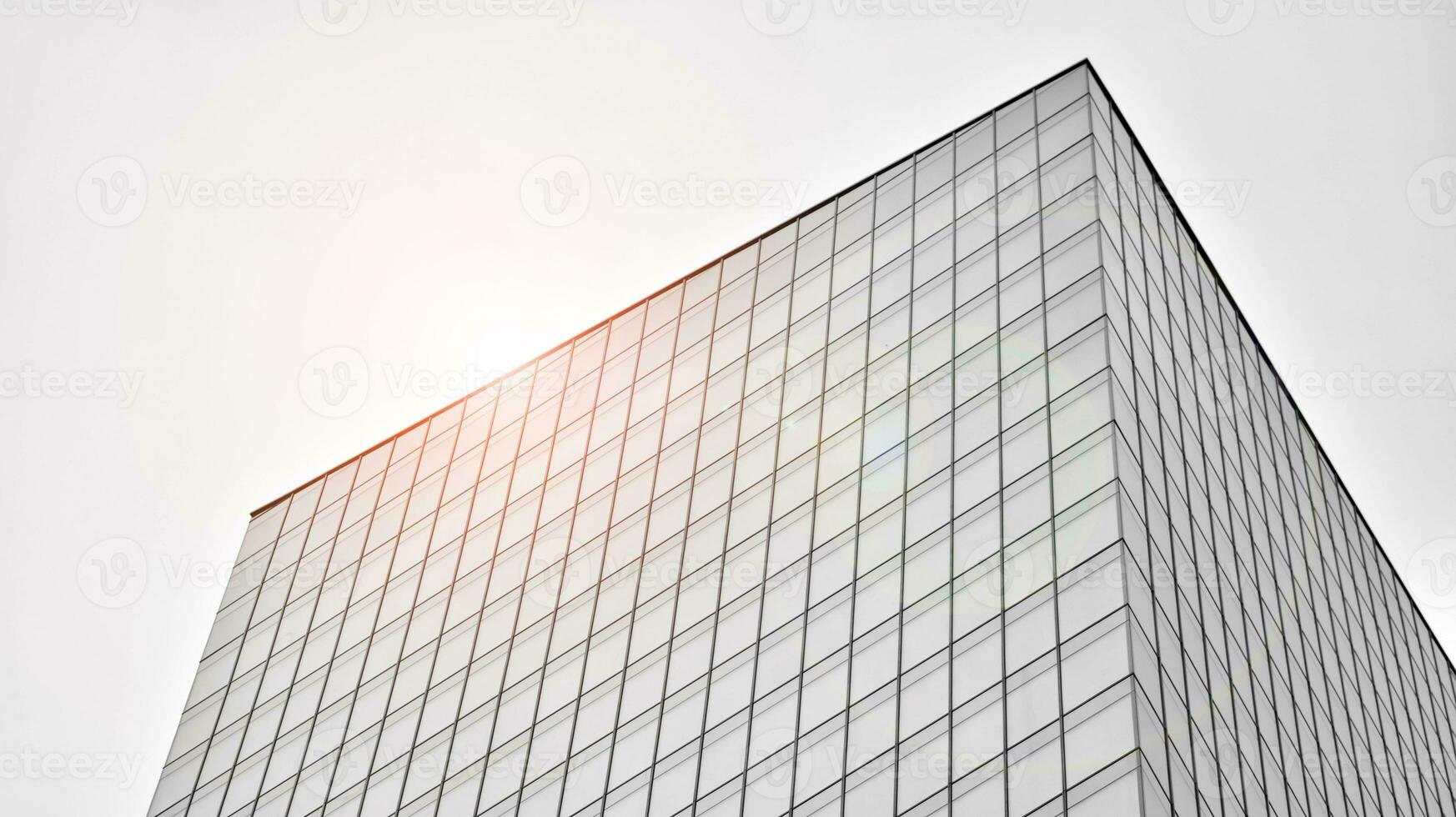 Glass modern building with blue sky background. View and architecture details. Urban abstract - windows of glass office building in  sunlight day. Black and white. photo