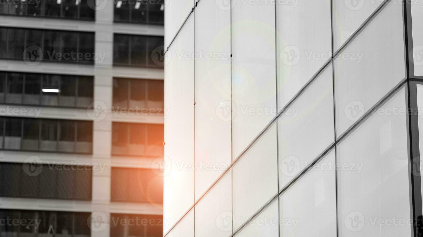 Glass modern building with blue sky background. View and architecture details. Urban abstract - windows of glass office building in  sunlight day. Black and white. photo