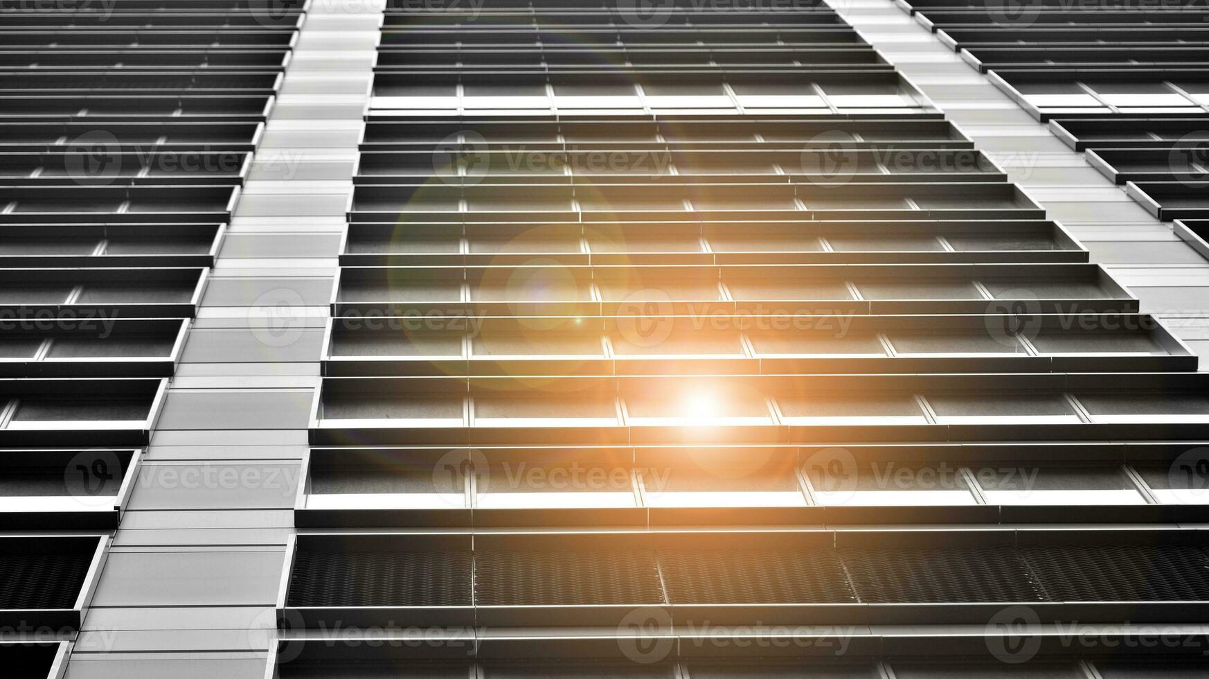 Glass modern building with blue sky background. View and architecture details. Urban abstract - windows of glass office building in  sunlight day. Black and white. photo