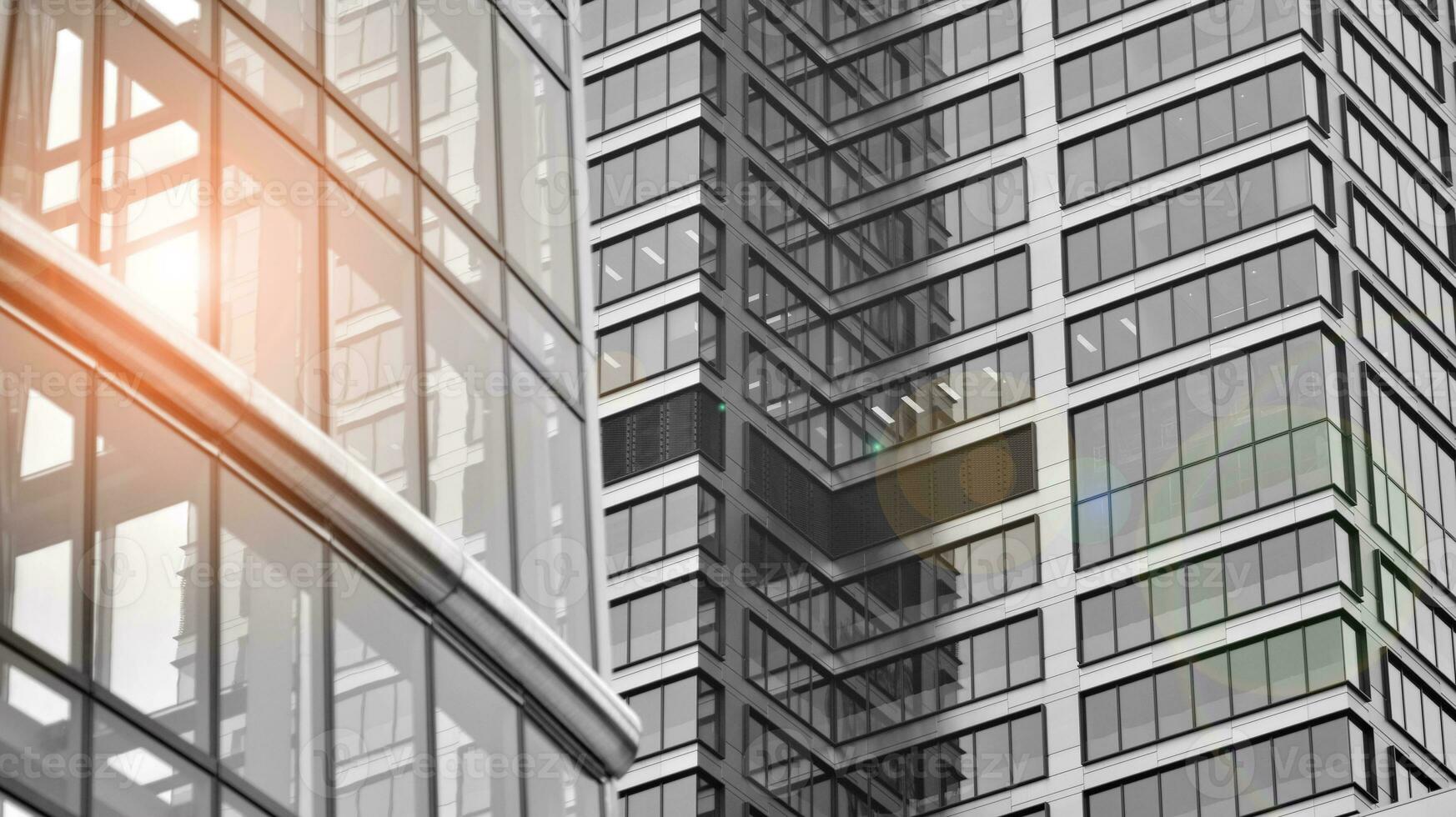 Glass modern building with blue sky background. View and architecture details. Urban abstract - windows of glass office building in  sunlight day. Black and white. photo