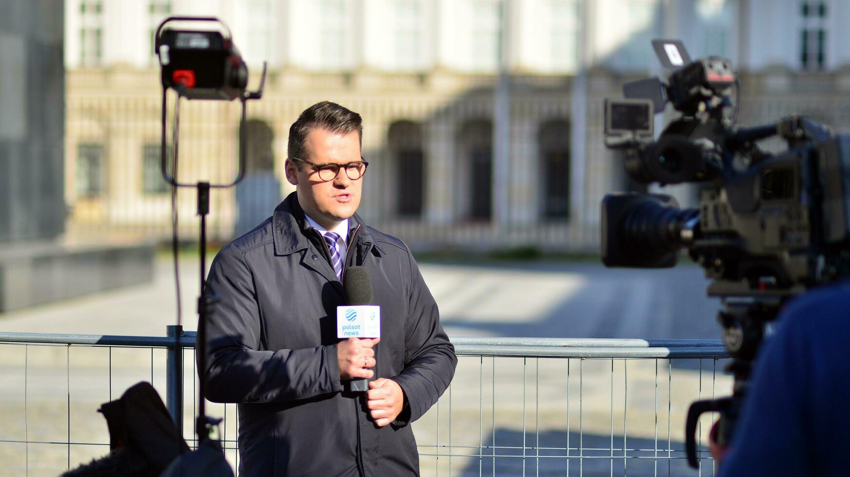 Warsaw, Poland. 24 October 2023. Group of professional journalists and reporters with video and photo camera do reportage and live stream. The presidential palace.