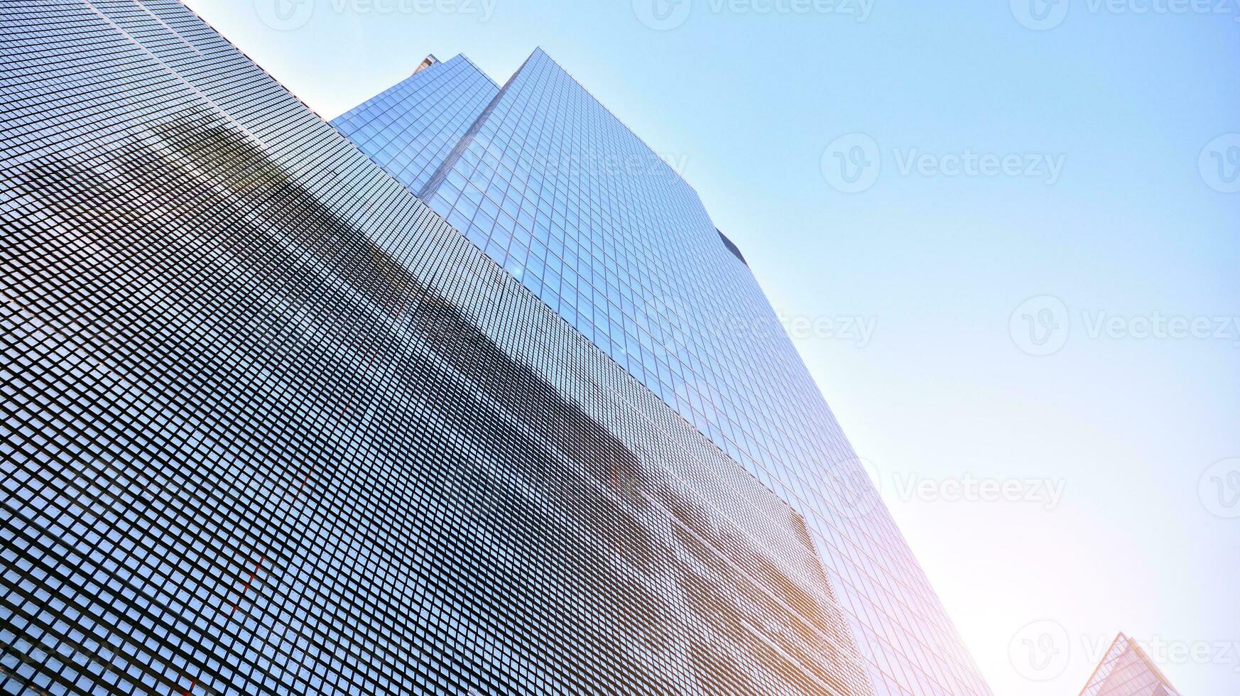 Bottom view of modern skyscrapers in business district against blue sky. Looking up at business buildings in downtown. photo