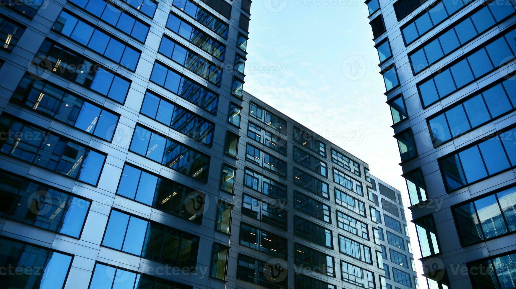 Bottom view of modern skyscrapers in business district against blue sky. Looking up at business buildings in downtown. photo