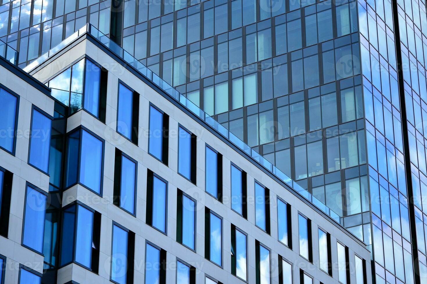 Modern office building with glass facade on a clear sky background. Transparent glass wall of office building. photo