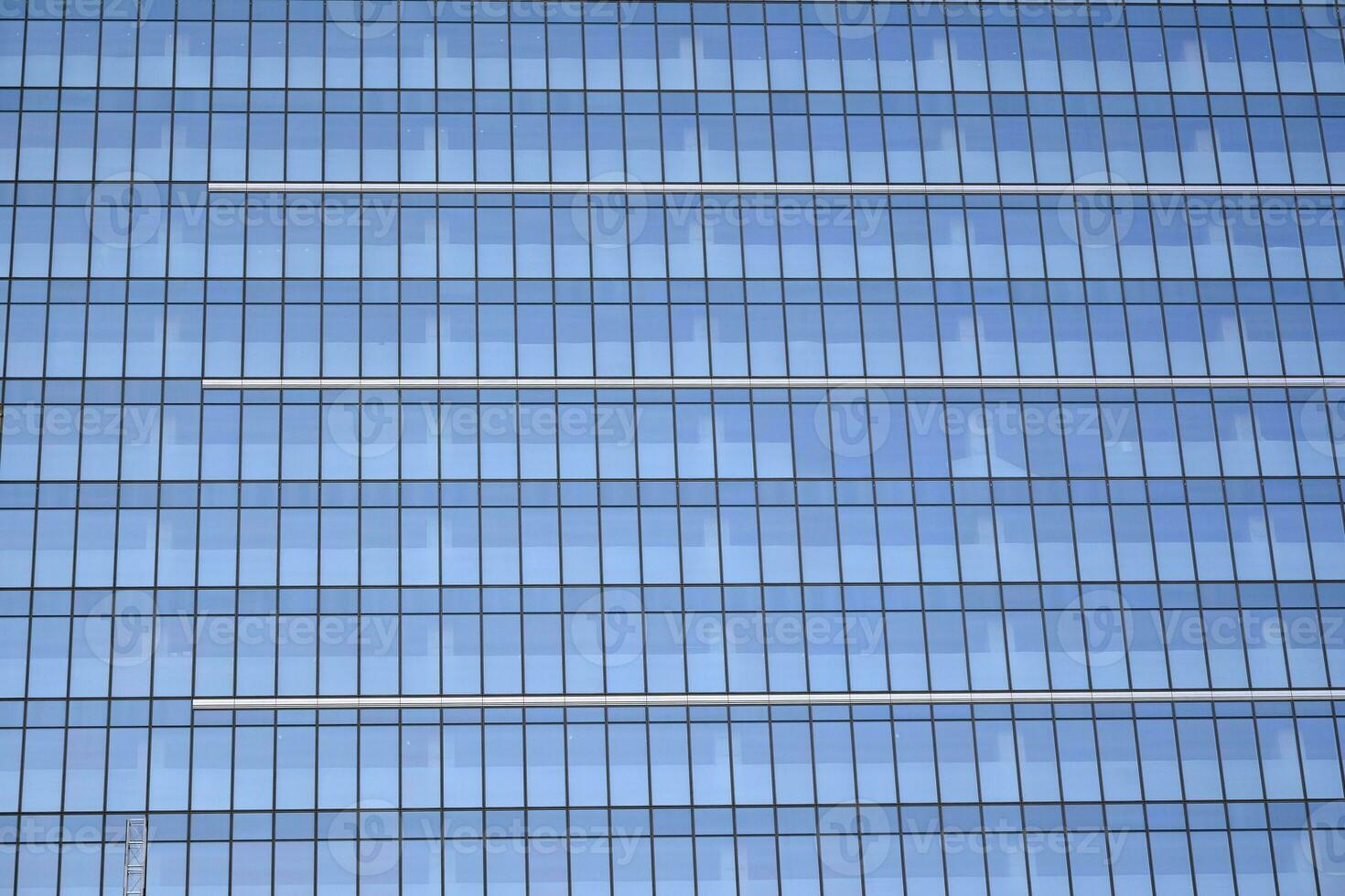 Modern office building with glass facade on a clear sky background. Transparent glass wall of office building. photo