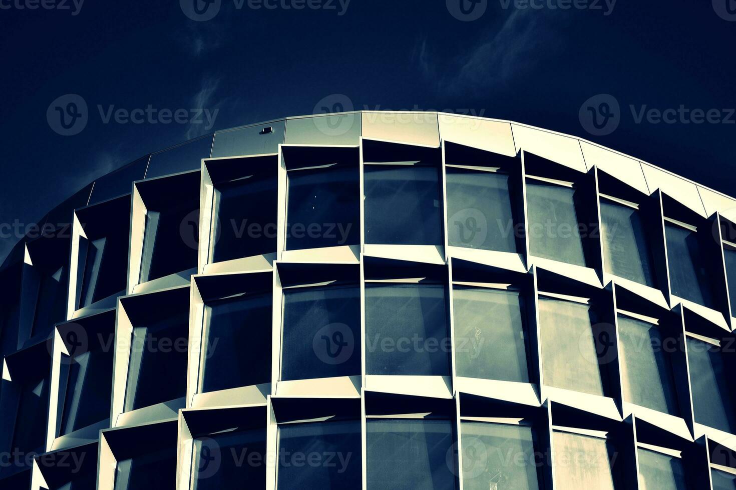Modern office building with glass facade on a clear sky background. Transparent glass wall of office building. photo