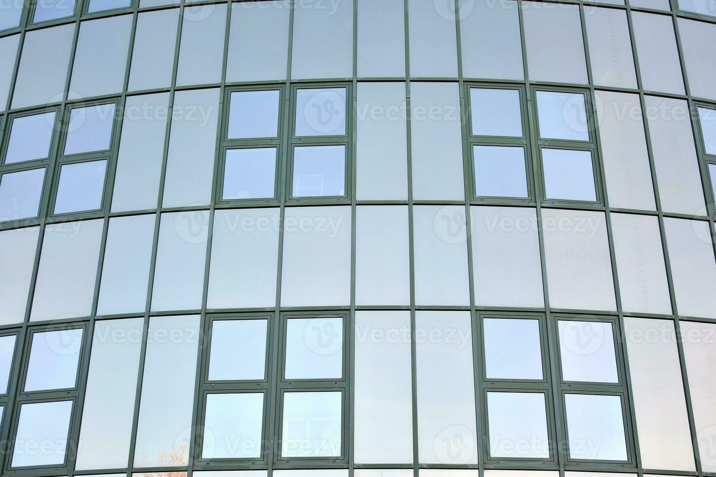 moderno oficina edificio con vaso fachada en un claro cielo antecedentes. transparente vaso pared de oficina edificio. foto