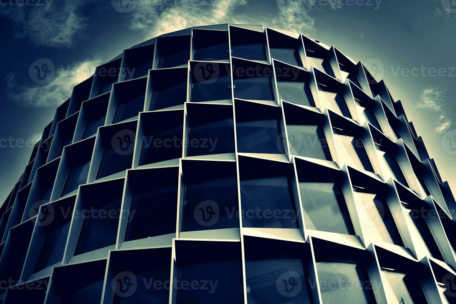 Modern office building with glass facade on a clear sky background. Transparent glass wall of office building. photo