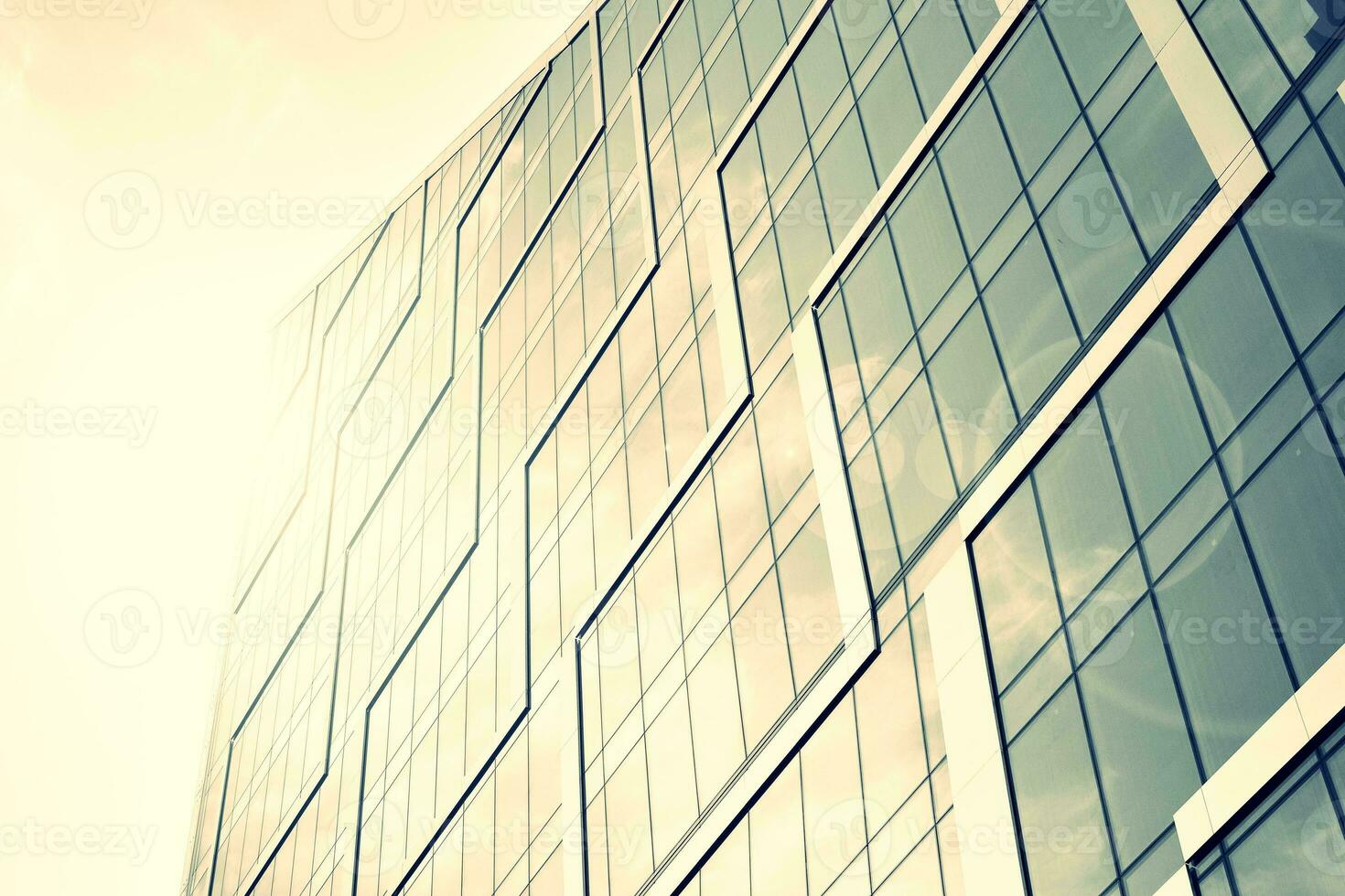 Modern office building with glass facade on a clear sky background. Transparent glass wall of office building. photo