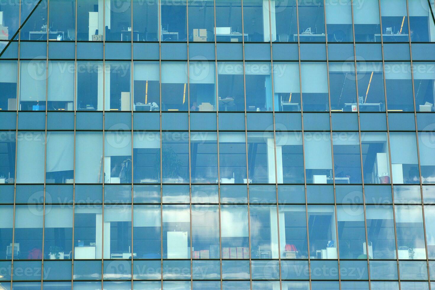 Glass building with transparent facade of the building and blue sky. Structural glass wall reflecting blue sky. Abstract modern architecture fragment. Contemporary architectural background. photo