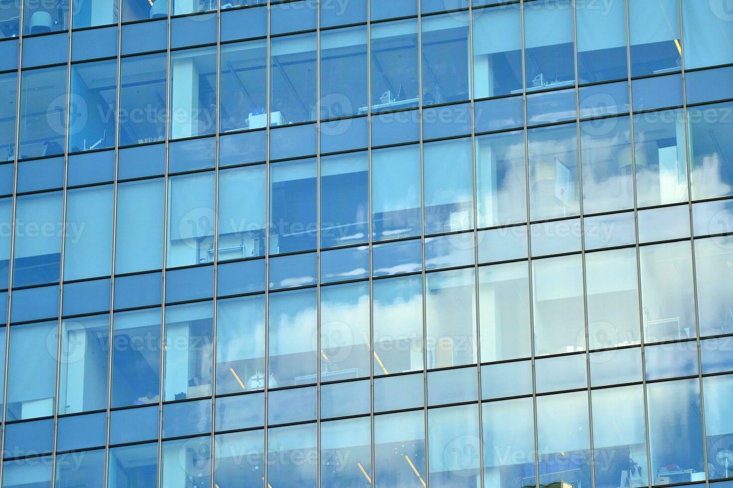 Glass building with transparent facade of the building and blue sky. Structural glass wall reflecting blue sky. Abstract modern architecture fragment. Contemporary architectural background. photo