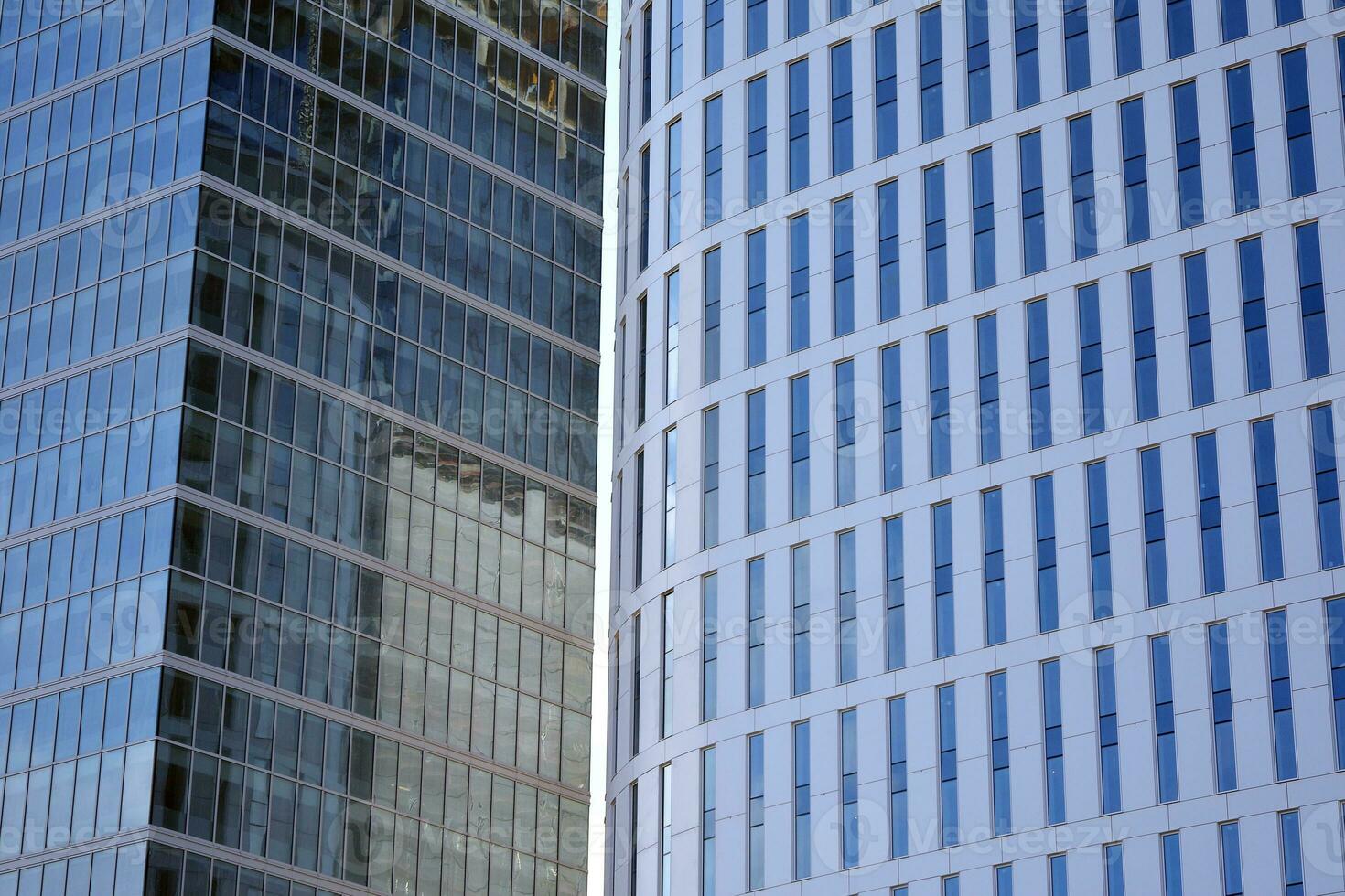 Glass building with transparent facade of the building and blue sky. Structural glass wall reflecting blue sky. Abstract modern architecture fragment. Contemporary architectural background. photo