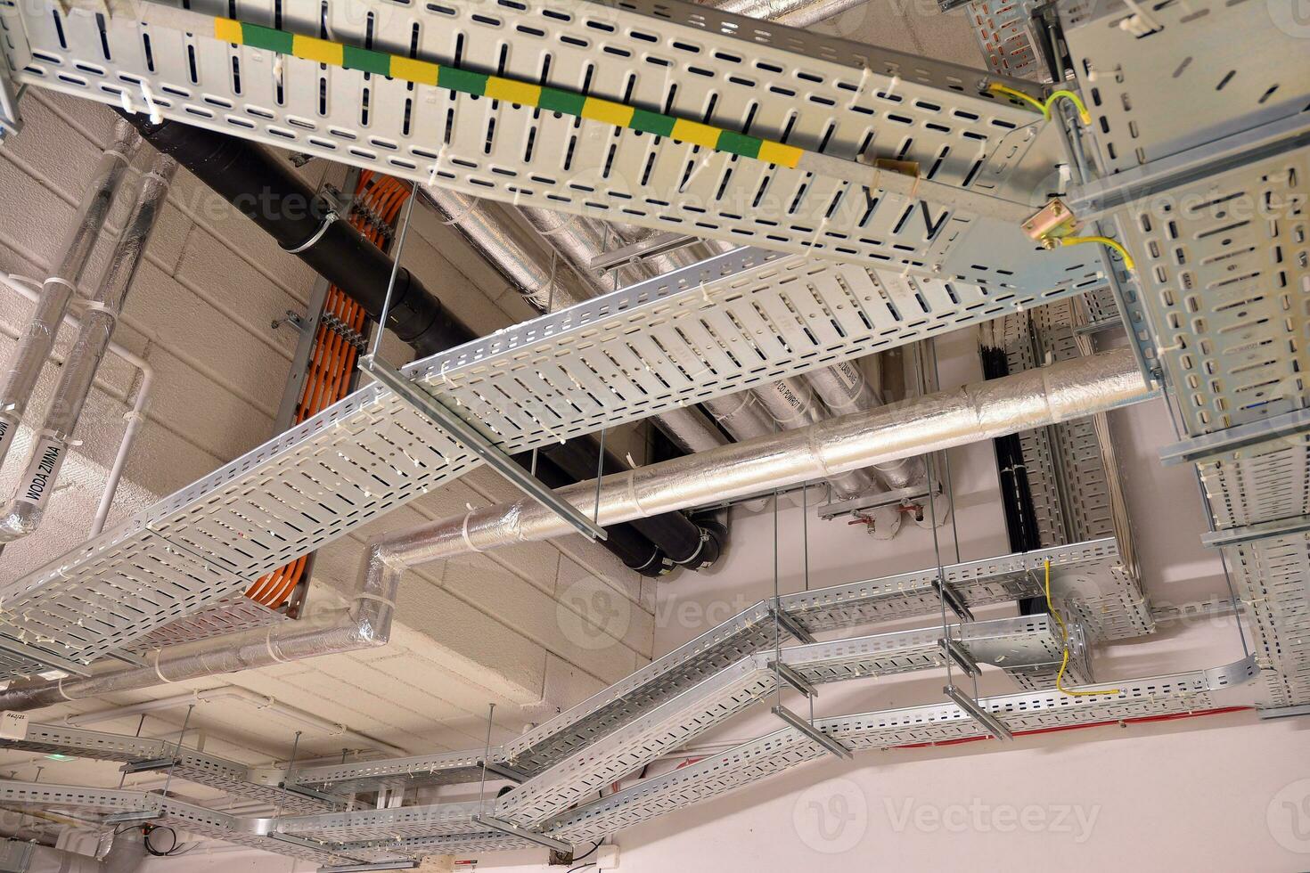 Sanitary system pipes and electrical cables installed under flat slab reinforced concrete structure in building. photo