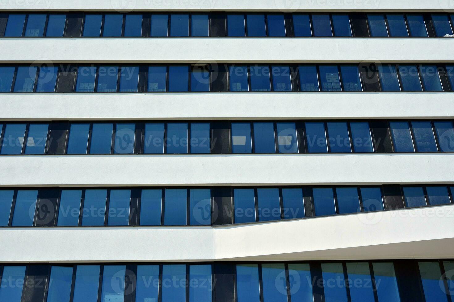 Modern office building in the city with windows and  steel and aluminum panels wall. Contemporary commercial architecture, vertical converging geometric lines. photo