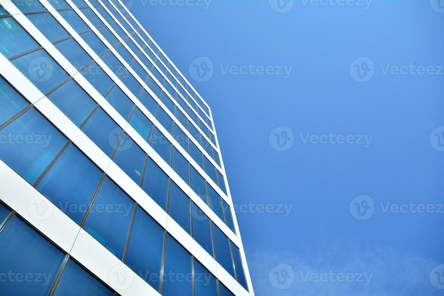 Modern office building in the city with windows and  steel and aluminum panels wall. Contemporary commercial architecture, vertical converging geometric lines. photo