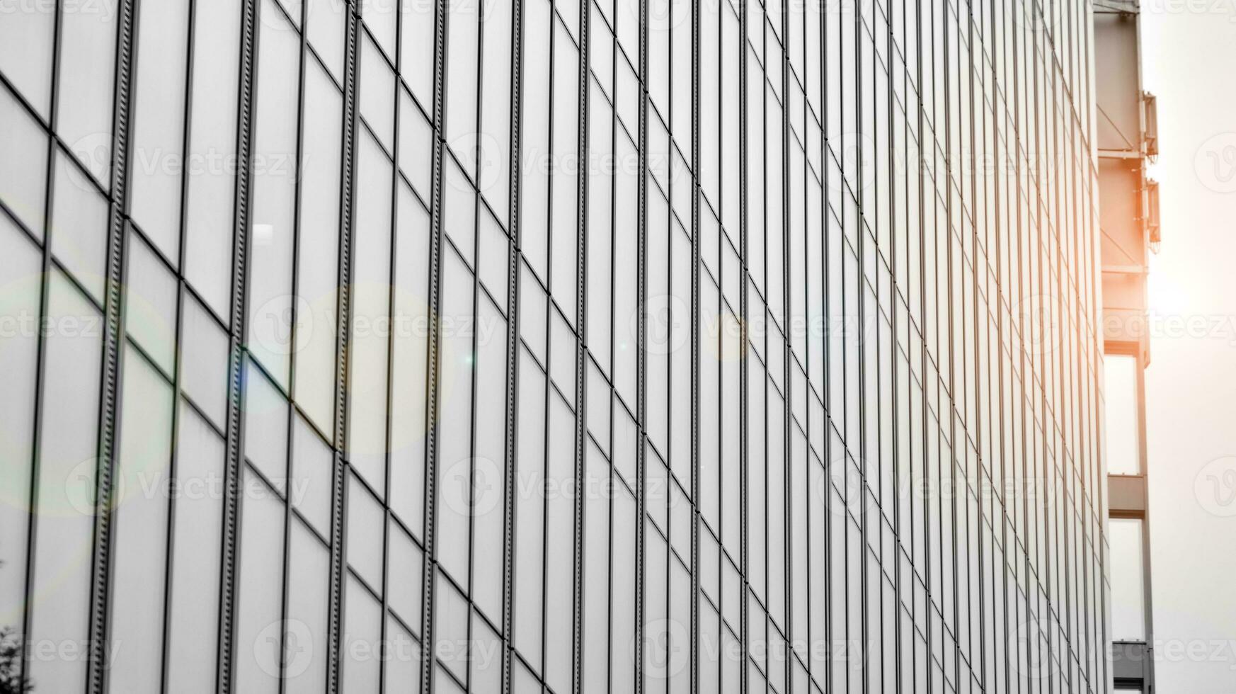 Glass modern building with blue sky background. View and architecture details. Urban abstract - windows of glass office building in  sunlight day. Black and white. photo