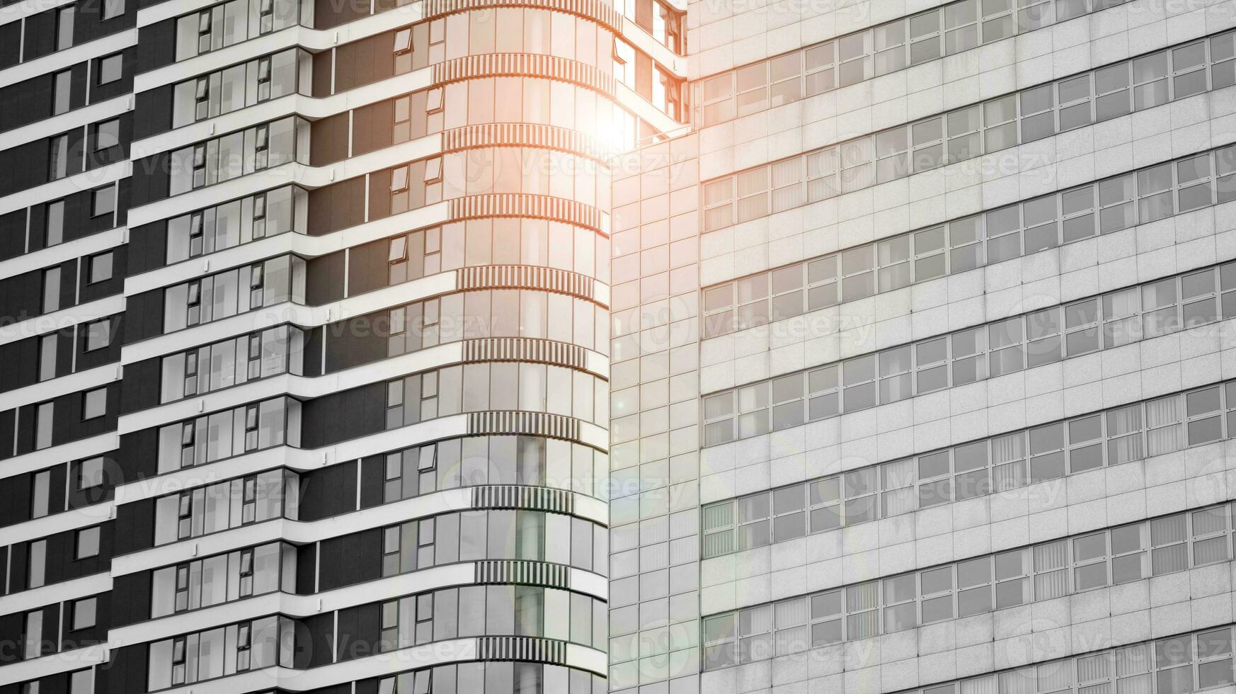 Glass modern building with blue sky background. View and architecture details. Urban abstract - windows of glass office building in  sunlight day. Black and white. photo