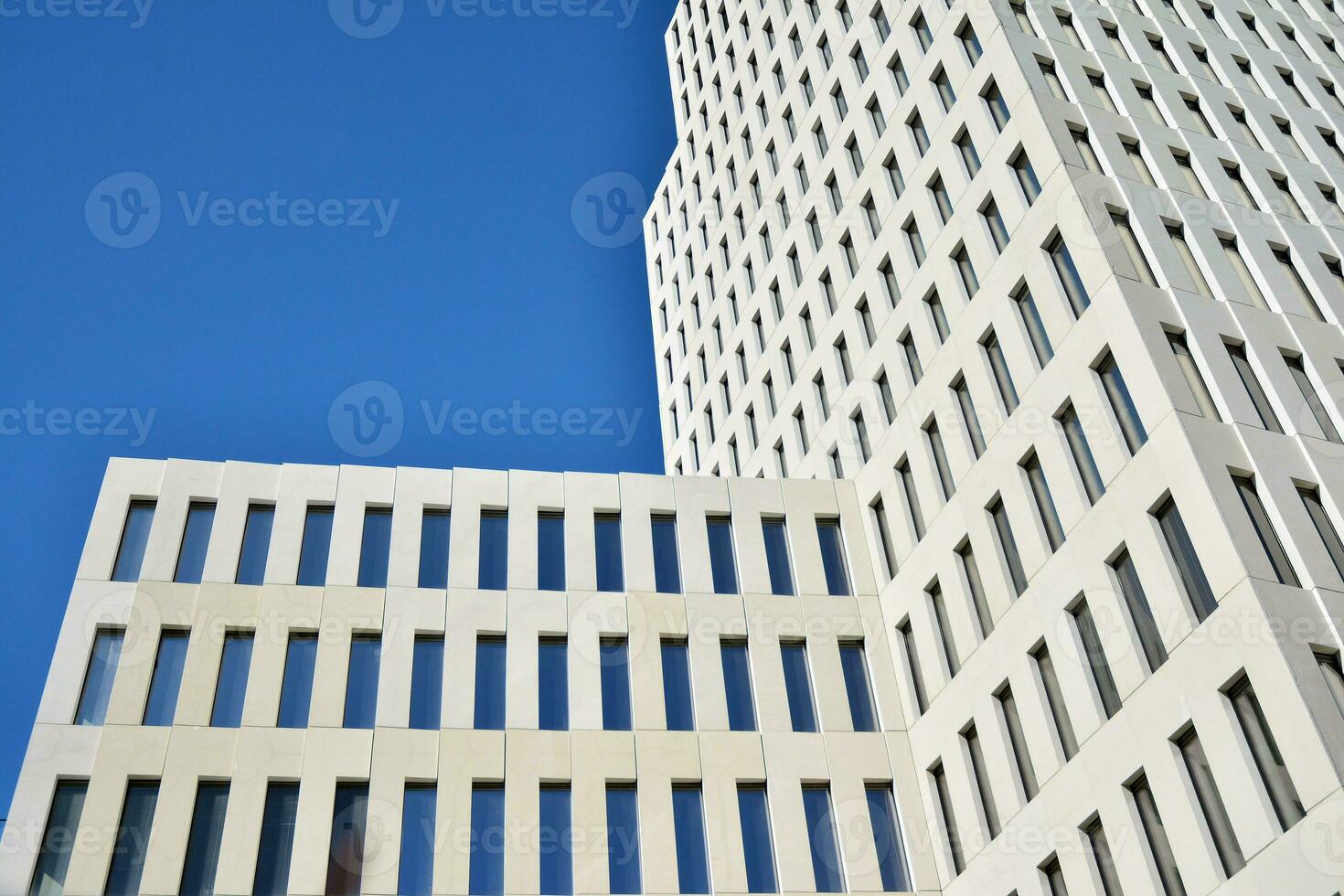 Modern office building detail. Perspective view of geometric angular concrete windows on the facade of a modernist brutalist style building. photo